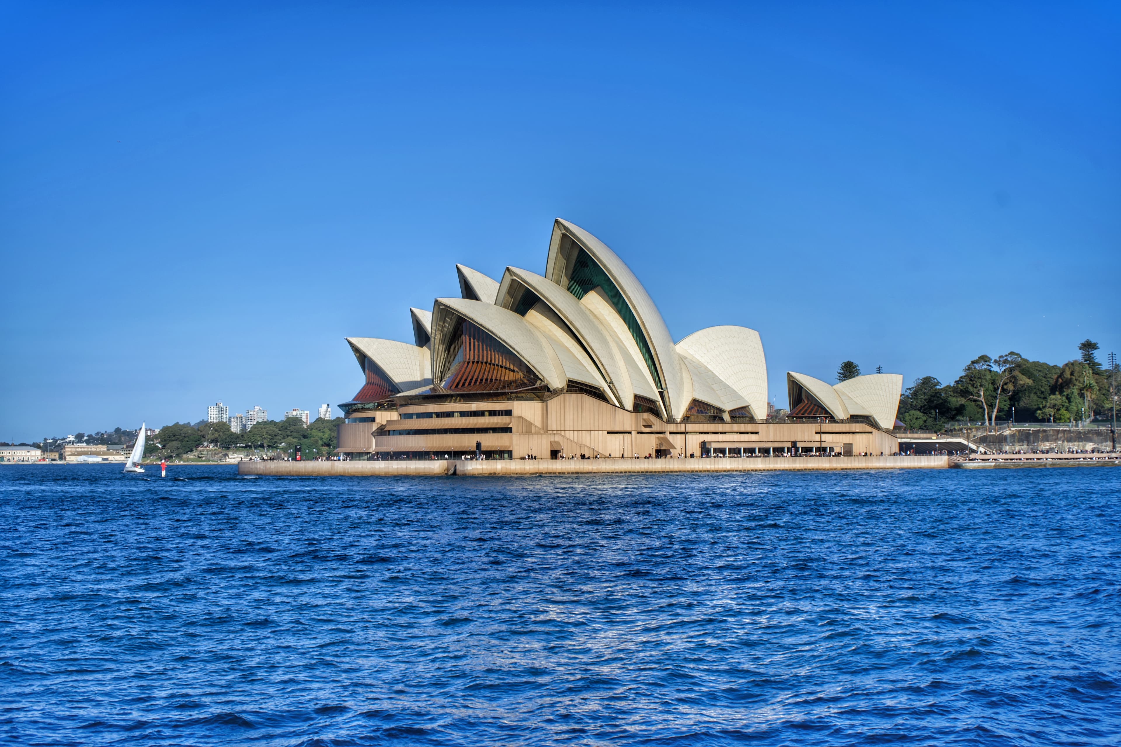 Sydney Opera House across blue harbour water, framed by a white border