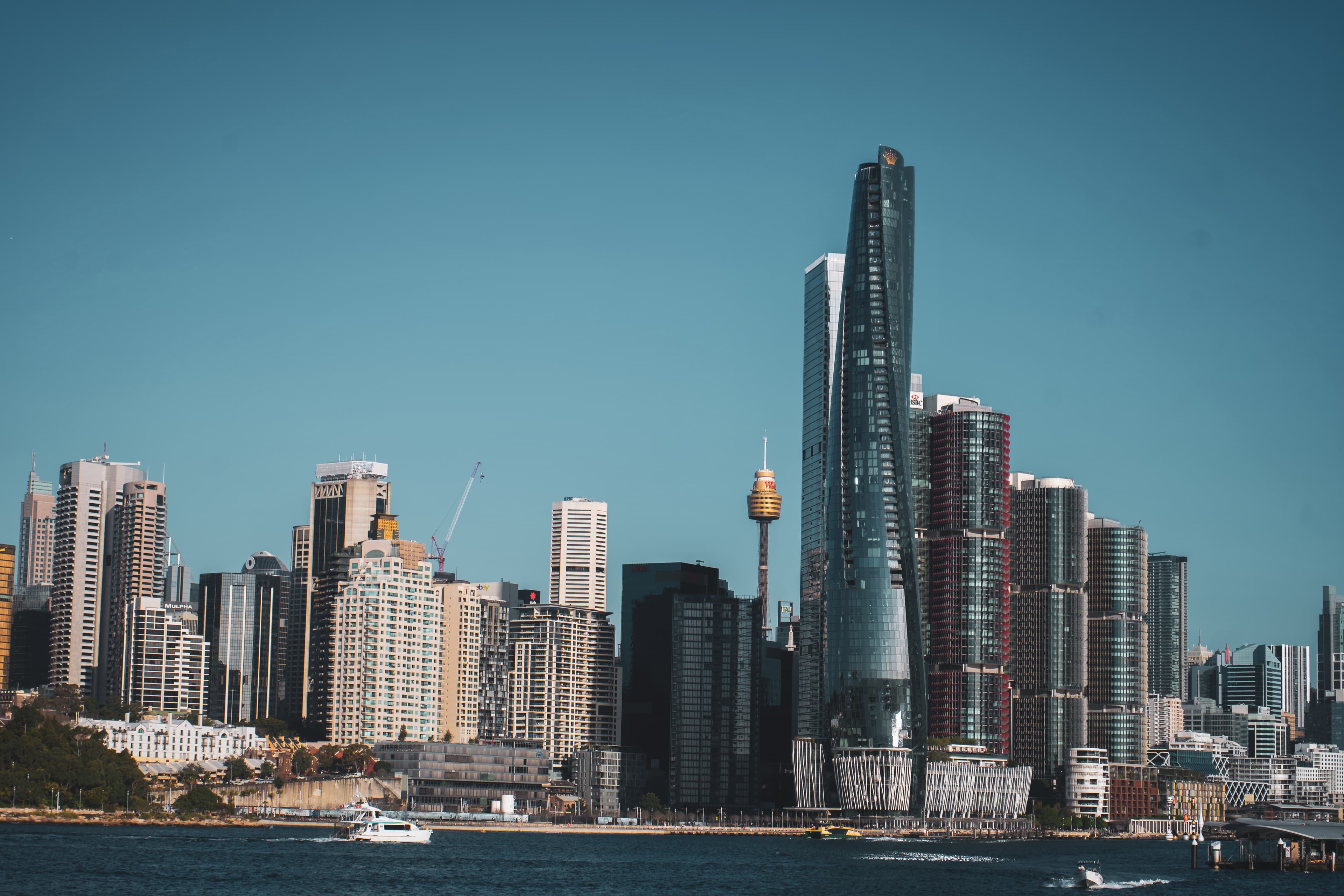 Waterfront skyline of high-rise buildings with boats crossing the harbour